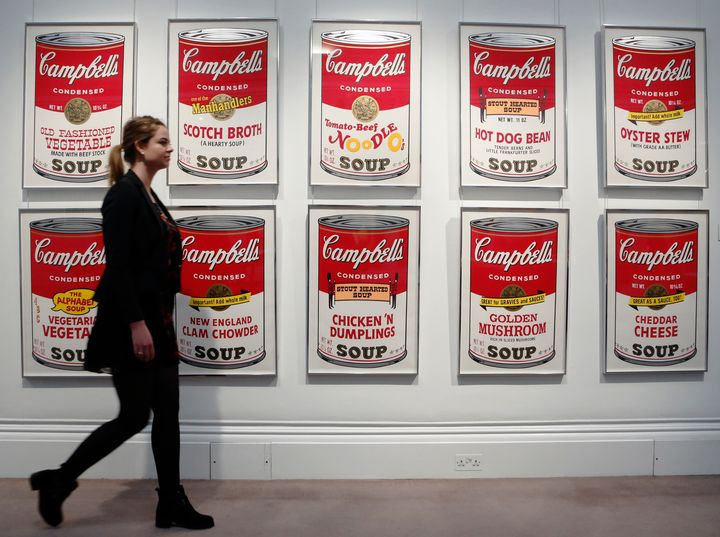Sotheby's worker, Isabelle Brown, poses with "Campbell's Soup II" by Andy Warhol at Sotheby's in London March 15, 2013.