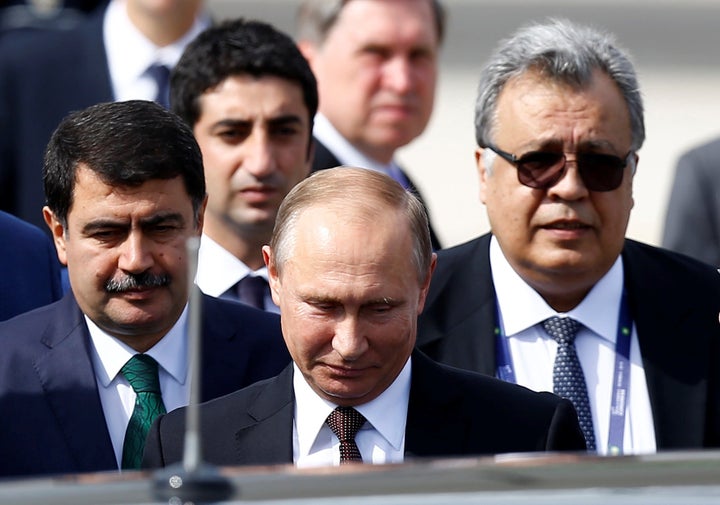 Andrei Karlov accompanies Vladimir Putin.