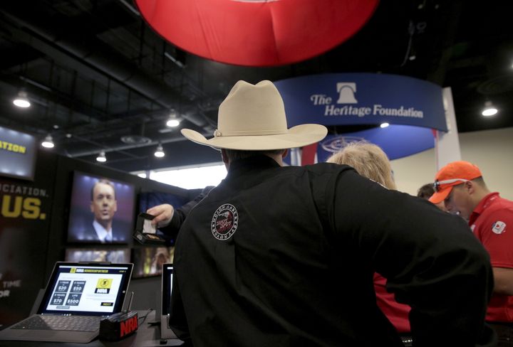 A man wearing a cowboy hat stops at the booth for the National Rifle Association (NRA) at the 2016 Conservative Political Action Conference (CPAC) at National Harbor, Maryland, March 4, 2016.