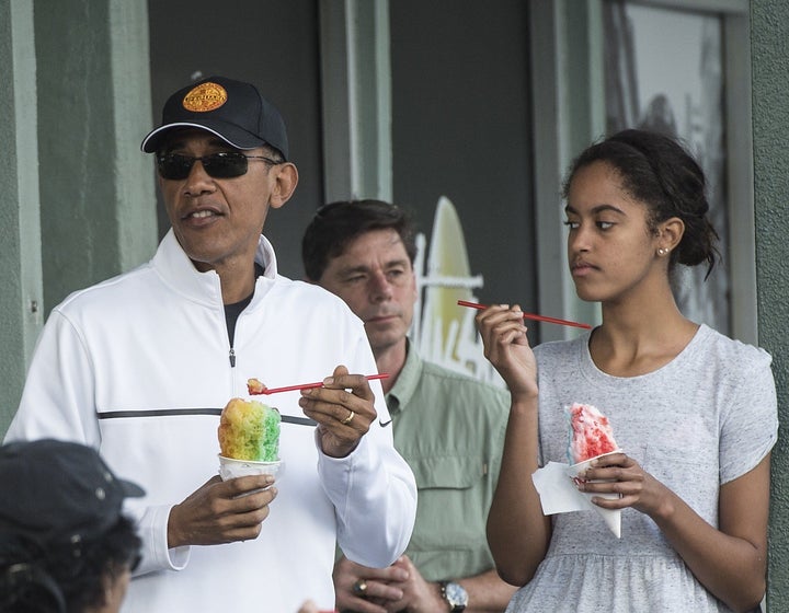 US President Barack Obama has shave ice with his daughter Malia at Island Snow in Kailua on January 1, 2015.