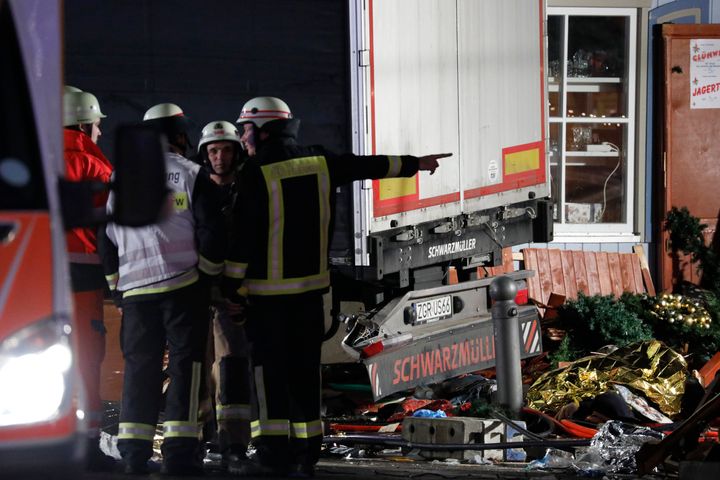 Firefighter stand beside a truck at a Christmas market in Berlin, Germany.