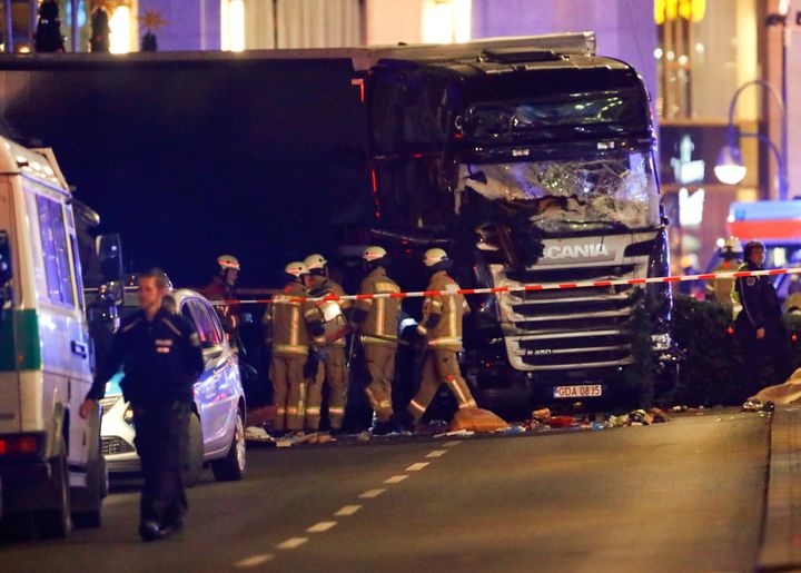 Police and emergency workers stand next to a crashed truck at the site of an accident at a Christmas market on Breitscheidplatz square.