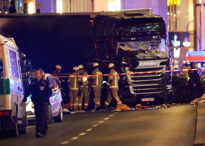 Police and emergency workers stand next to a crashed truck at the site of an accident at a Christmas market on Breitscheidplatz square.