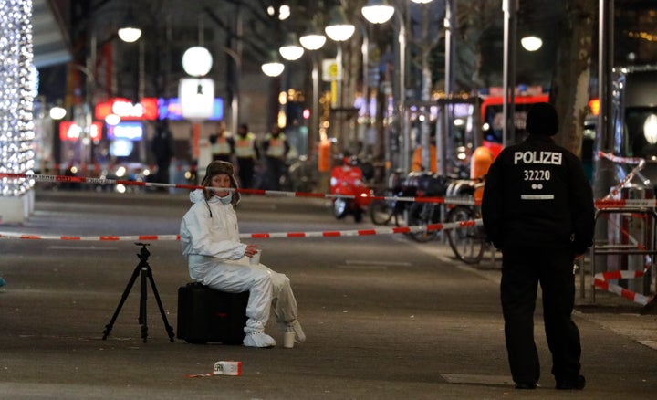 A German police investigator rests at a Christmas market following an accident with a truck.