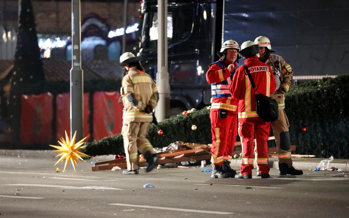 Paramedics and fire fighters talk beside a truck at a Christmas market in Berlin, Germany.