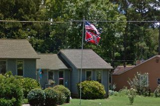 In a photo taken last year, a Confederate flag is seen flying outside the home of the former Roswell, Georgia, police sergeant.