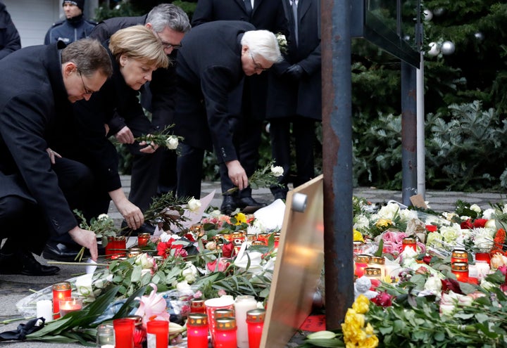 From left, the Mayor of Berlin Michael Mueller, German Chancellor Angela Merkel, German Interior Minister Thomas de Maiziere and German Foreign Minister Frank-Walter Steinmeier attend a flower ceremony at the Kaiser-Wilhelm-Gedaechniskirche in Berlin.