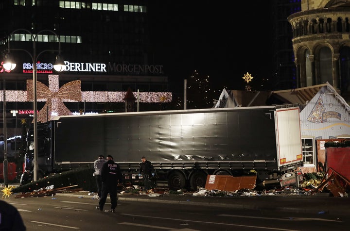 <strong>Police officers stand beside a truck which ran into a crowded Christmas market and killed several people in Berlin.</strong>