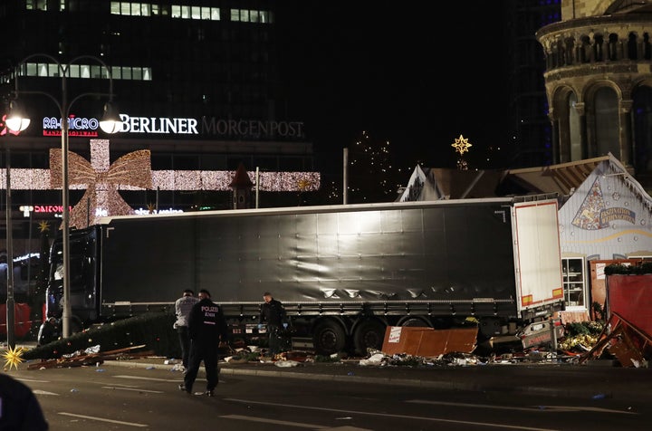 Police officers stand beside a truck which ran into a crowded Christmas market and killed several people in Berlin.