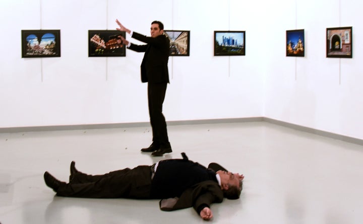 Andrei Karlov (front), the Russian ambassador to Ankara, lies on the floor next to his killer Mevlut Mert Altintas who still point his gun to people attending an art exhibition in Ankara, on December 19, 2016.