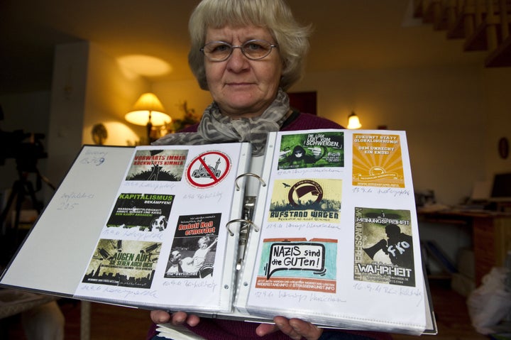 Schramm displays a scrap book containing far right and Nazi stickers she has removed from public places over the years.