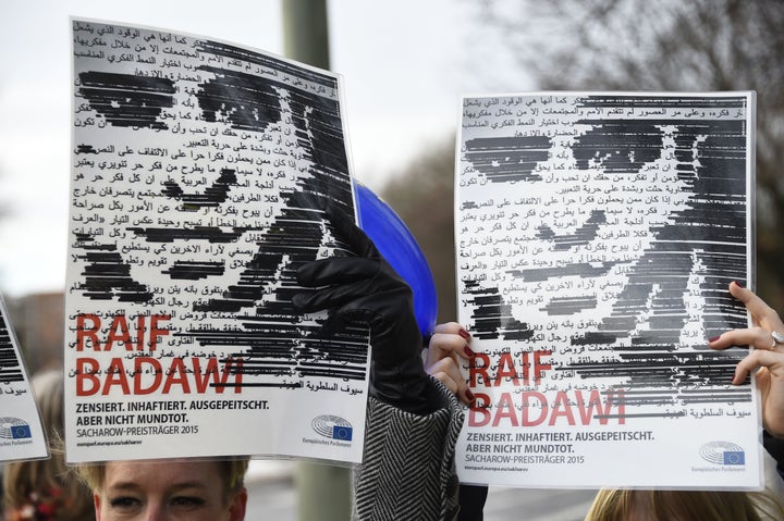 Members of Human rights NGO Amnesty International hold up portraits of jailed Saudi blogger Raif Badawi as they demonstrate in front of the embassy of Saudi Arabia in Berlin, on January 8, 2016 to ask for his release.