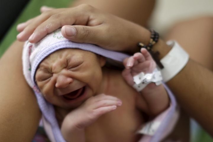 Sueli Maria (obscured) holds her daughter Milena, who has microcephaly, (born seven days ago), at a hospital in Recife, Brazil, January 28, 2016.