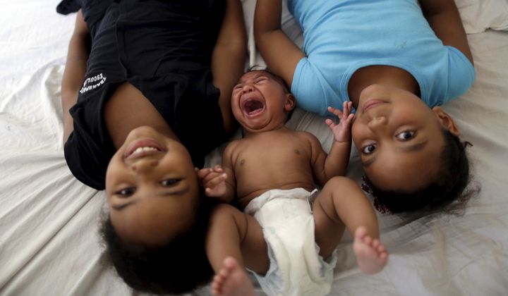 Maria Clara (L) and Camile Vitoria pose for picture with their brother Matheus, who has microcephaly, in Recife, Brazil, January 27, 2016.