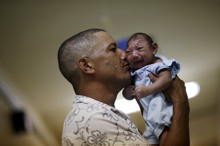 Maria Clara (L) and Camile Vitoria pose for picture with their brother Matheus, who has microcephaly, in Recife, Brazil, January 27, 2016.