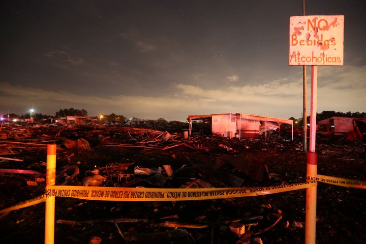 A sign reading "No alcoholic beverages" is seen next to flattened houses after the explosion