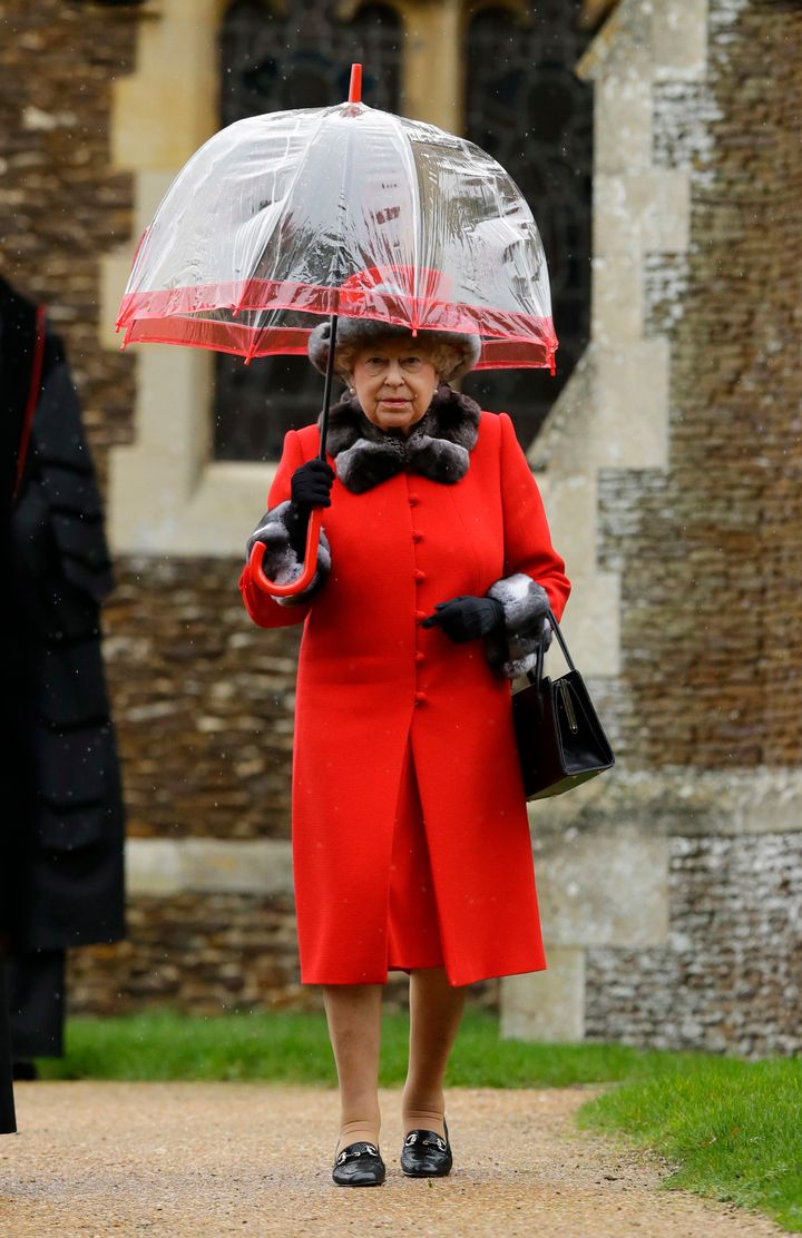 The Queen shelters under an umbrella after attending the royal family's traditional Christmas Day church service at St Mary Magdalene Church in Sandringham, 2015