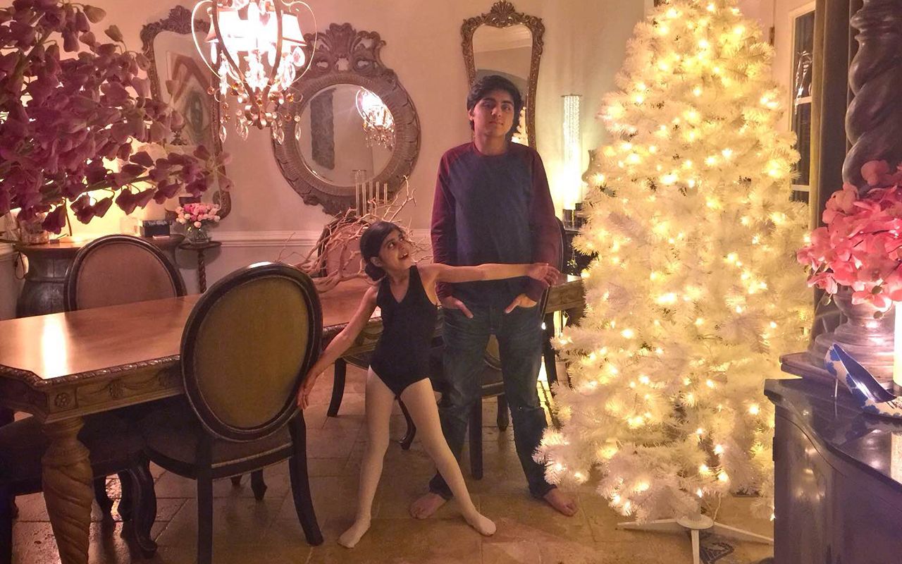 Malik's children, Eesa and Enaya, stand in front of their family Christmas tree.