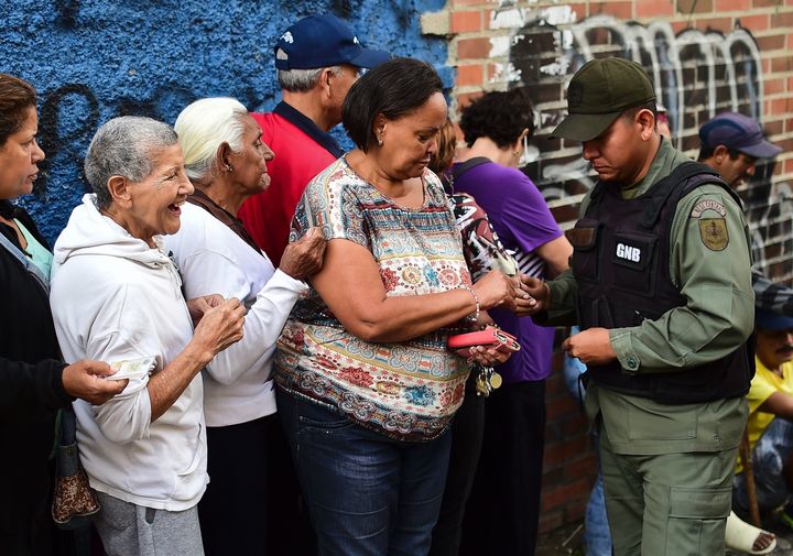 People queue to buy basic food and household items outside a supermarket in the poor neighbourhood of Lidice, in Caracas, Venezuela