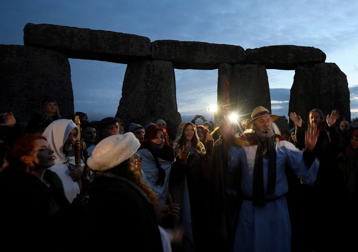 Visitors and revelers react amongst the prehistoric stones of the Stonehenge monument at dawn on Winter Solstice, the shortest day of the year, December 21, 2016.