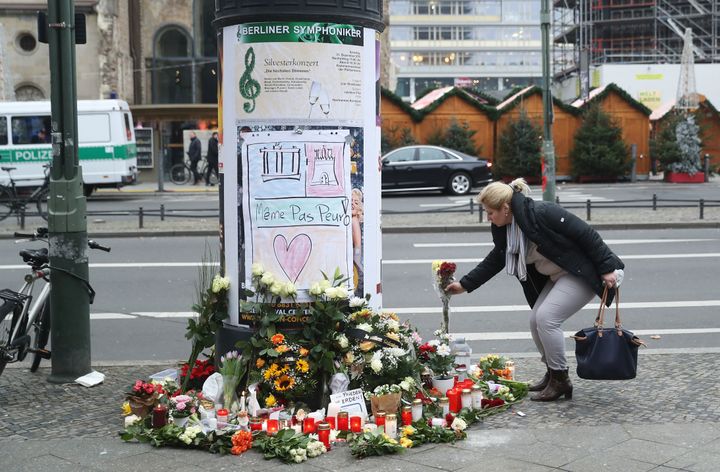 <strong>A woman lays flowers near where yesterday a lorry ploughed through a Christmas market in Berlin</strong>