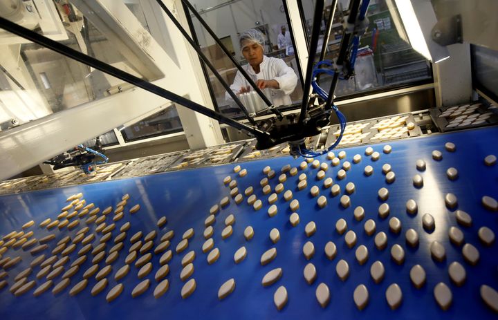 An employee checks robotic arms picking up traditional sweets from Provence at a French factory on Dec. 15.