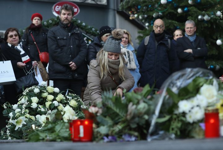 Mourners lay flowers and candles at a makeshift memorial at the site of the attack 