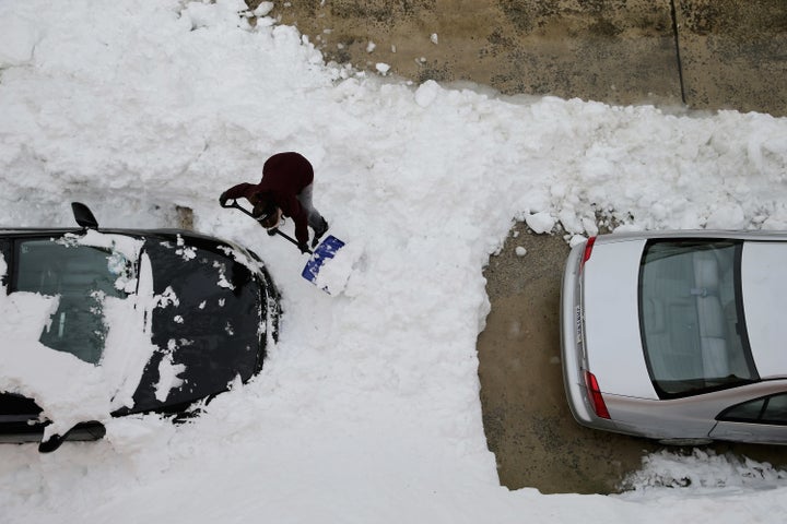 A woman attempts to dig her car out from underneath nearly 20 inches of snow in Washington, D.C., Jan. 26, 2016.