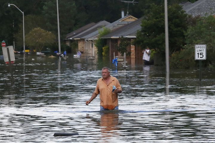 A man wades through a flooded street in Ascension Parish, Louisiana, Aug. 15, 2016.
