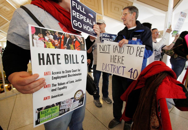 Opponents of North Carolina's HB2 law limiting bathroom access for transgender people protest in the gallery above the state'
