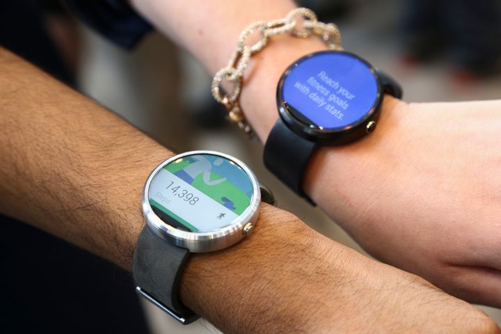 Google employees show off the two different colors of the Moto smartwatch at the Google I/O developers conference in San Francisco June 25, 2014.