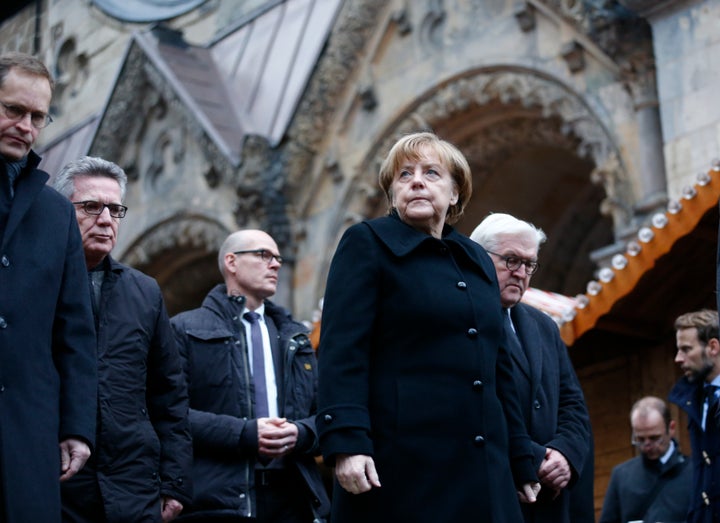 German Chancellor Angela Merkel and German Foreign Minister Frank-Walter Steinmeier walk towards the Christmas market in Berlin a day after it was attacked.