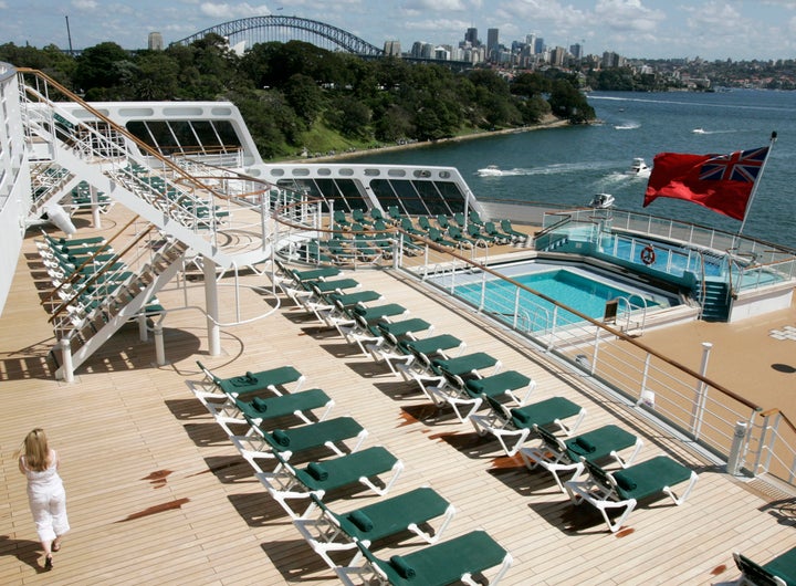 A passenger walks on Deck 8 featuring swimming pools near the stern of the Queen Mary 2 moored at Garden Island in Sydney February 20, 2007.