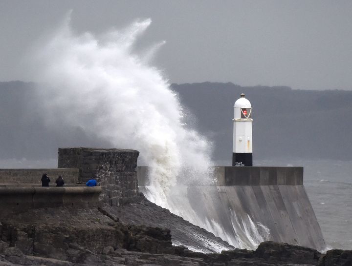 Waves crash over the lighthouse at Porthcawl, Wales.