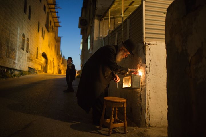 An ultra-orthodox Jewish man lights candles on the sixth night of the Jewish holiday of Hanukkah, in a religious neighborhood of Jerusalem on Dec. 2, 2013.