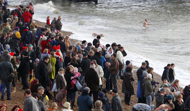 <strong>Spectators gather on the beach to watch the few dozen foolhardy swimmers on Christmas Day</strong>
