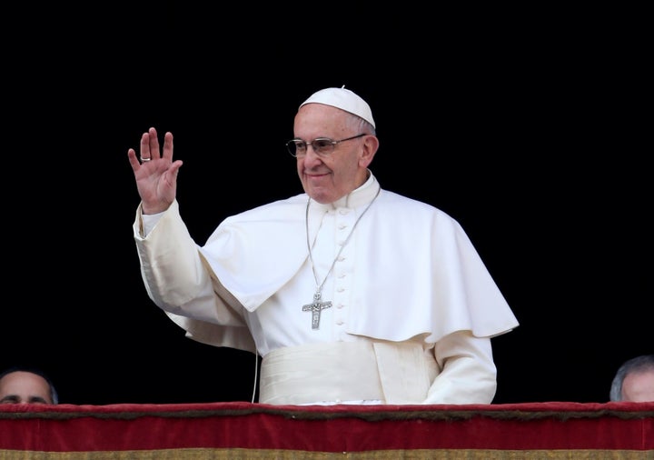 Pope Francis waves as he arrives to deliver the "Urbi et Orbi" message from the balcony overlooking St. Peter's Square at the