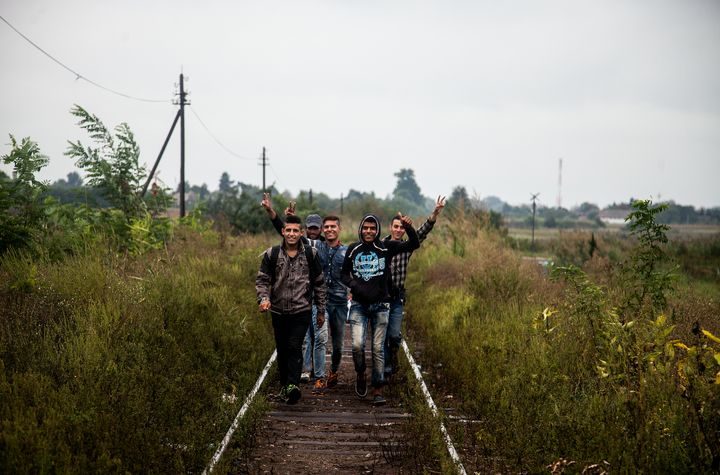 Young migrants and refugees walk along train tracks between Serbia and Hungary.