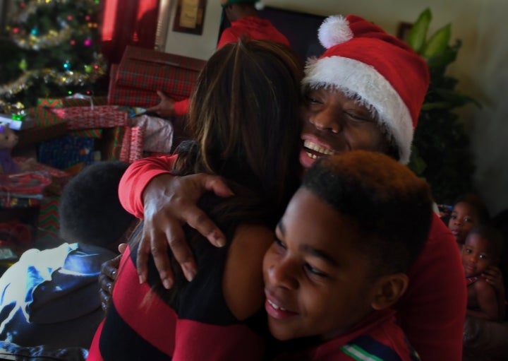 Tyshika Britten, with her 11-year-old son Na'zhia Bolden, gives a hug of thanks to Shirley Luu, a local businesswoman who sto