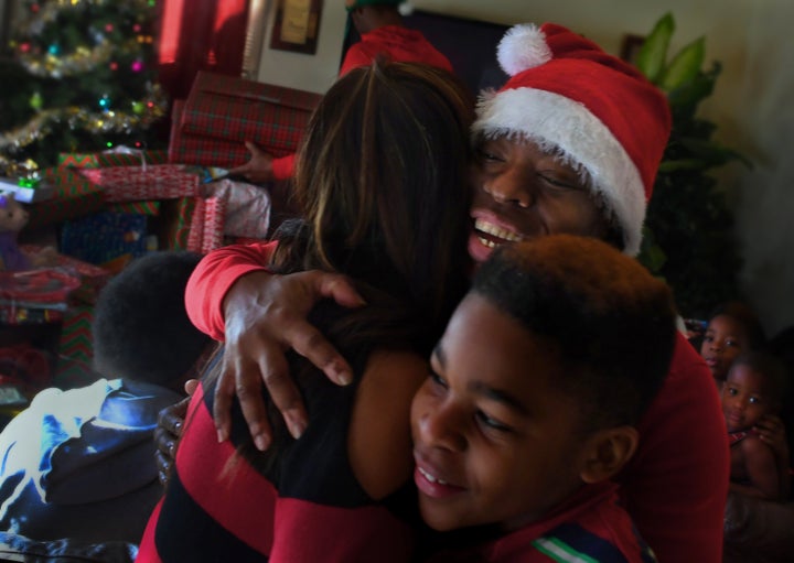 Tyshika Britten, with her 11-year-old son Na'zhia Bolden, gives a hug of thanks to Shirley Luu, a local businesswoman who stopped by to give the family some gifts and money. 