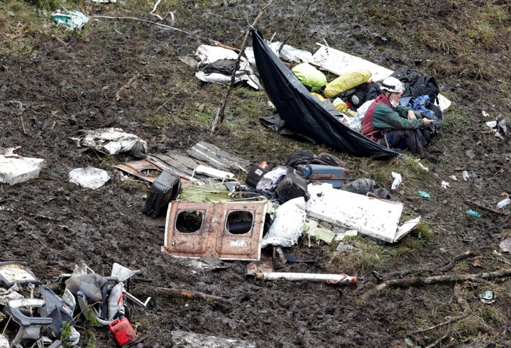 A rescue worker sits near the wreckage of a plane that crashed into the Colombian jungle with Brazilian soccer team Chapecoen