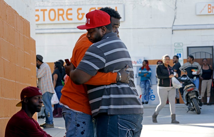 Two men embrace near the scene of a fatal shooting in Raleigh, N.C., Monday, Feb. 29, 2016. Authorities say that a police officer shot and killed a man while trying to make an arrest for a felony drug charge.