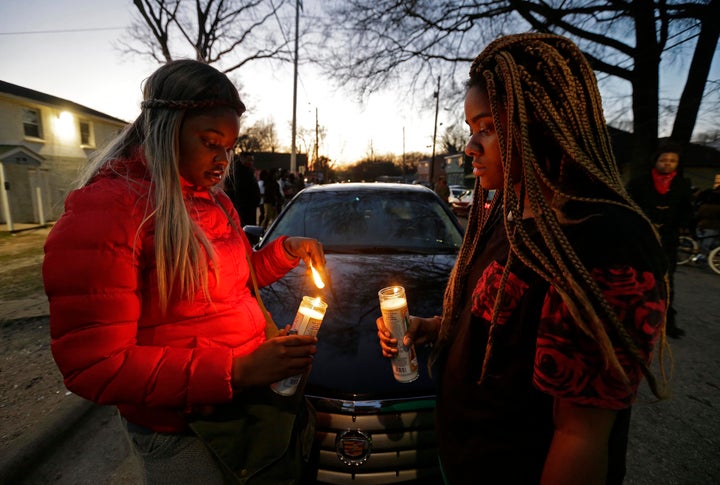 Destiny Brown, left, and Bonnie King light candles during a vigil near the scene of a fatal shooting in Raleigh, N.C., Monday, Feb. 29, 2016. Authorities say that a police officer shot and killed a man while trying to make an arrest for a felony drug charge.