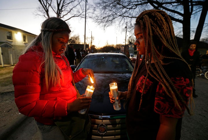 Destiny Brown, left, and Bonnie King light candles during a vigil near the scene of a fatal shooting in Raleigh, N.C., Monday, Feb. 29, 2016. Authorities say that a police officer shot and killed a man while trying to make an arrest for a felony drug charge. 