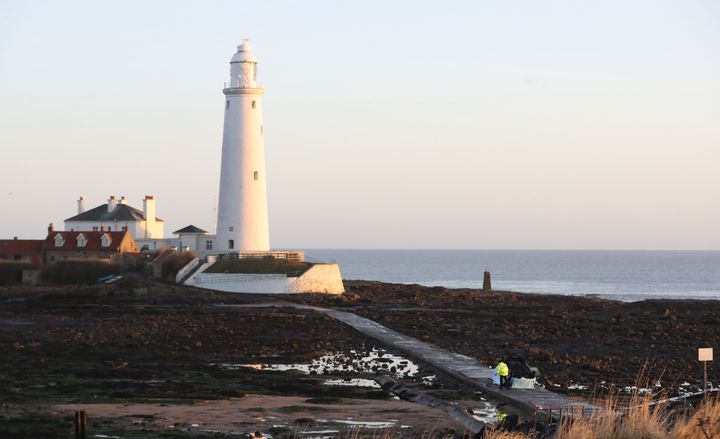 A car on its roof lies on the causeway at St Mary's Lighthouse, Whitley Bay.