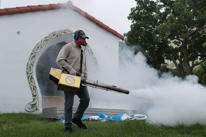 Carlos Varas, a Miami-Dade County mosquito control inspector, uses a Golden Eagle blower to spray pesticide to kill mosquitos in the Miami Beach neighborhood as the county fights to control the Zika virus outbreak on August 24, 2016 in Miami Beach, Florida.