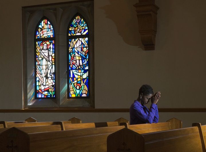 A woman prays inside a church.