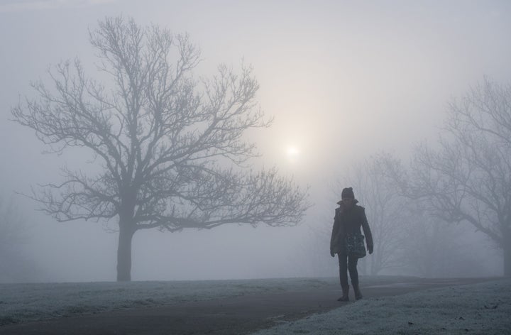 A woman walks in the fog at Blythe Hill Fields, in south east London