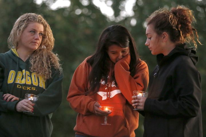 People take part in a candlelight vigil for victims of the Umpqua Community College shooting.