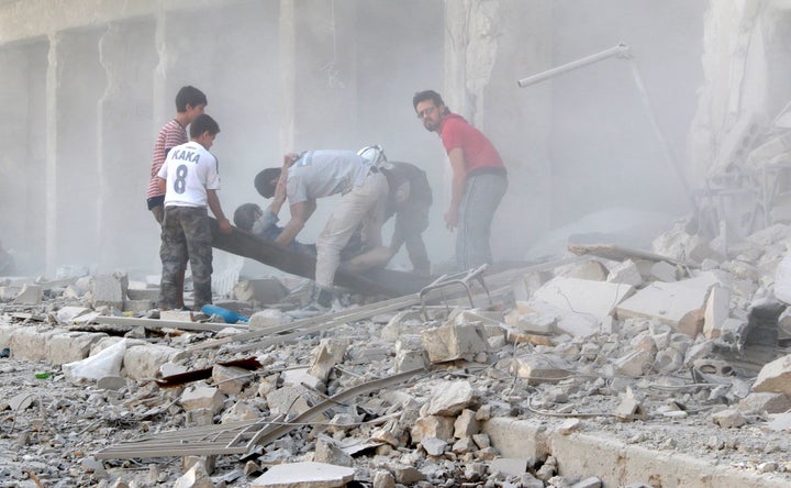 Search and rescue team members evacuate casualties from the rubbles after the Syrian regime forces airstrikes hit Aleppo's opposition controlled Al-Ansari town, Syria on Thursday,